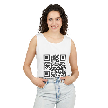 A woman with curly dark hair wearing a white sleeveless tank top with a large black QR code graphic on the front, paired with light-wash jeans, against a plain white background.